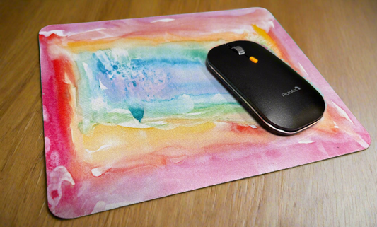 Colorful mouse pad with a wireless mouse on a wooden surface