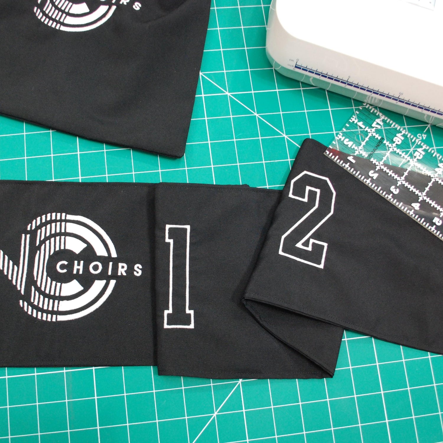 Black drawstring bag and black fabric number line with Logo and numbers embroidered on it.