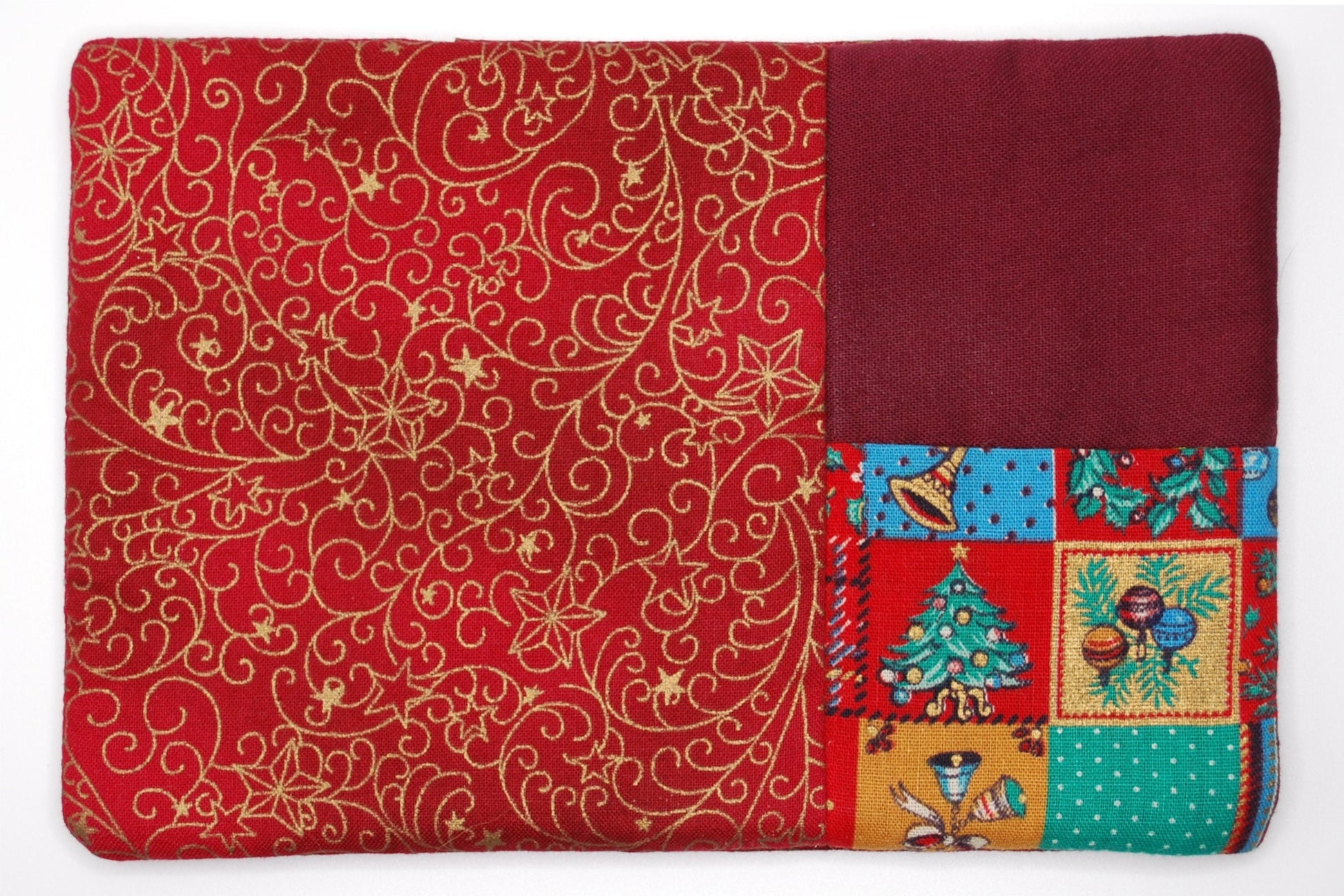 A mug run with red patterned section and Christmas-themed patchwork section on a white background