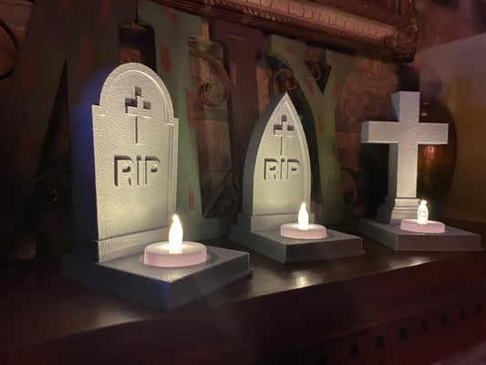 Angled view of the Halloween graveyard tea light holder set showing the stone-textured finish and glowing flameless candles