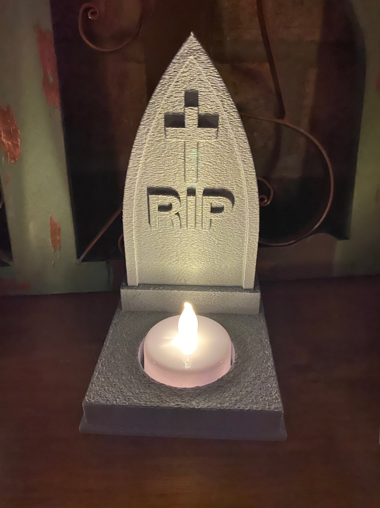 Pointed gothic arch tombstone candle holder with carved RIP lettering and a flickering electric tea light