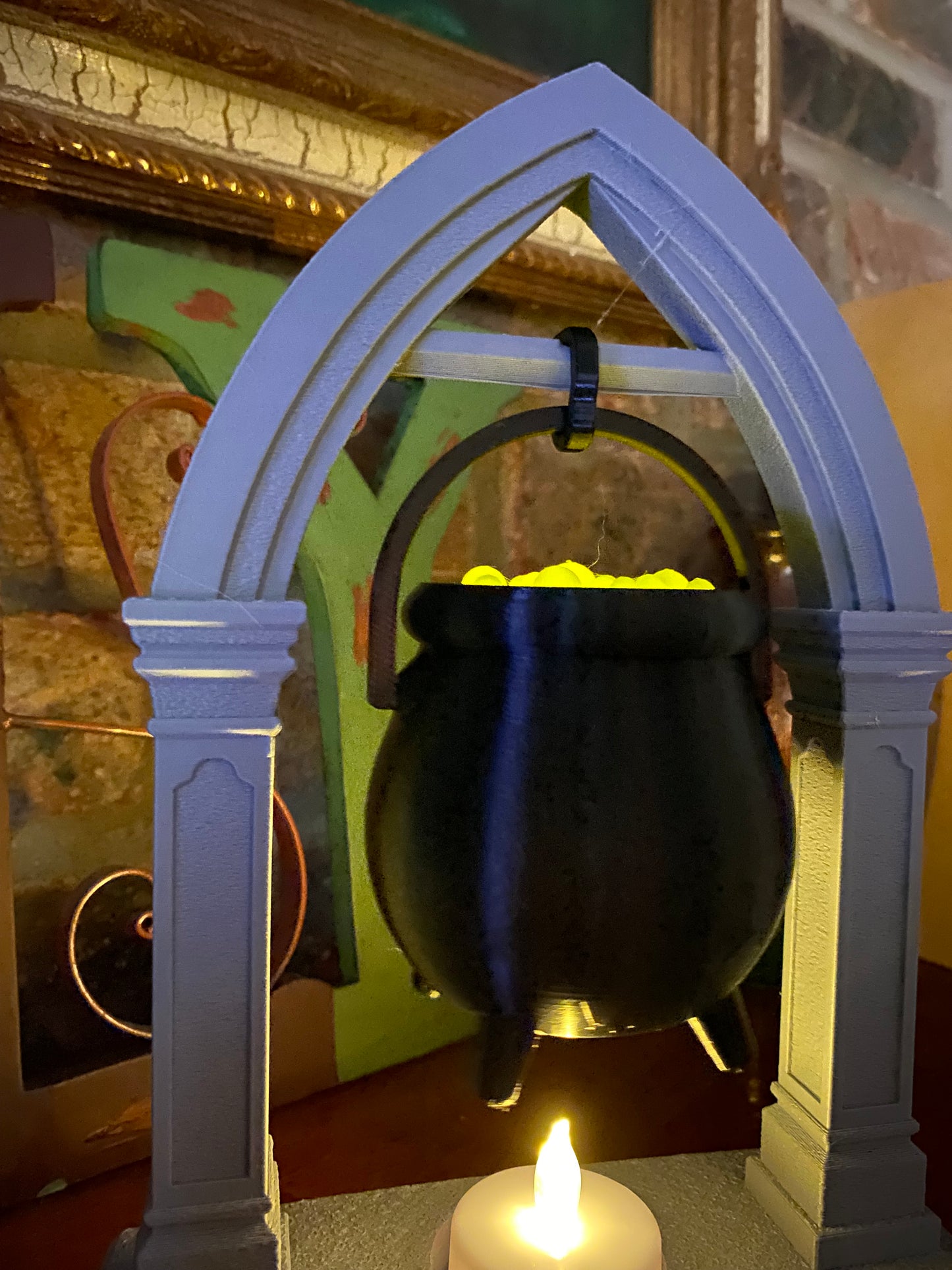 Close-up of bubbling green potion glowing inside the black cauldron, hung by its handle from the stone-textured gothic arch
