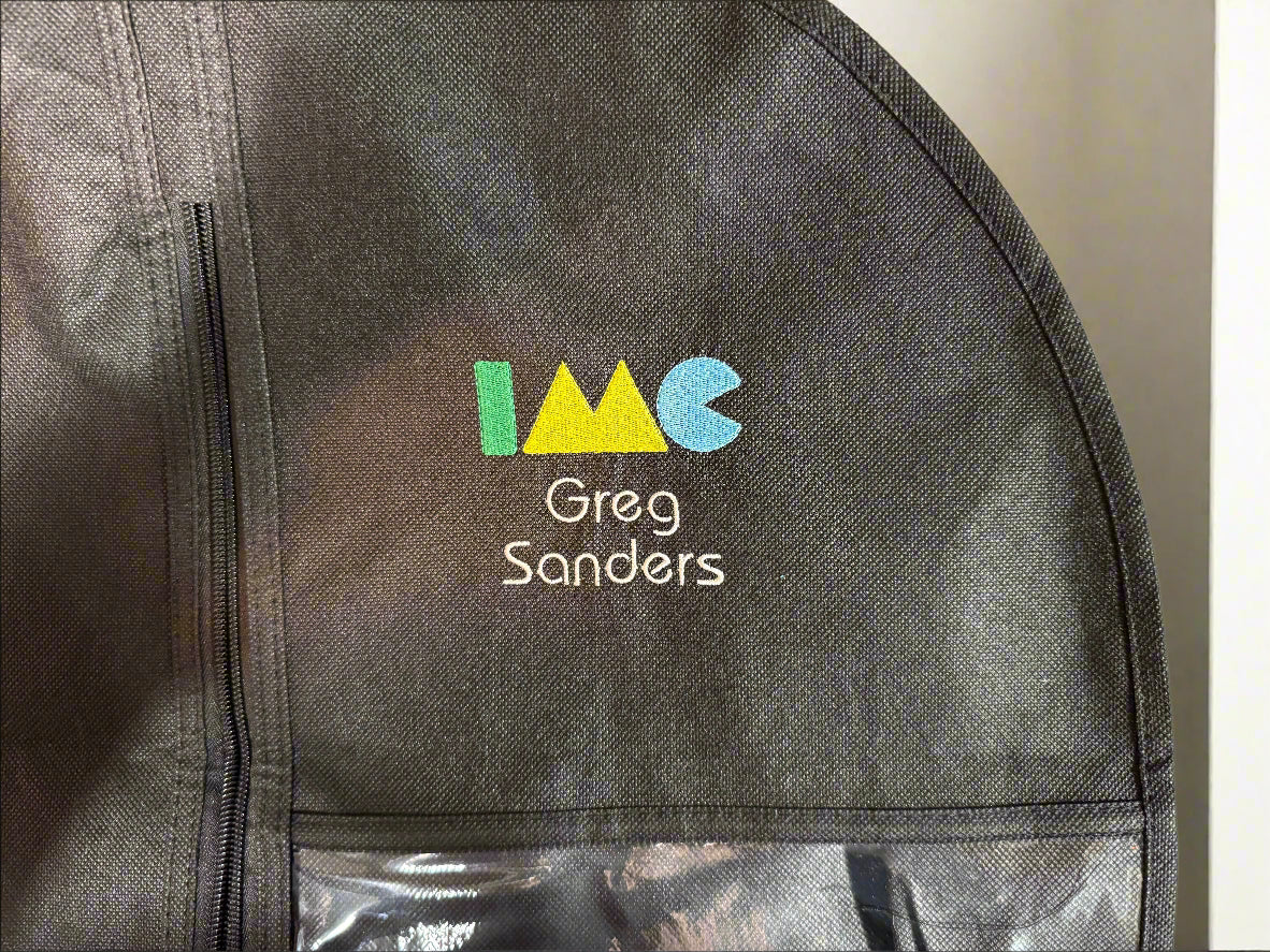 Black garment bag with colorful logo and text 'IMC Greg Sanders' on a plain background