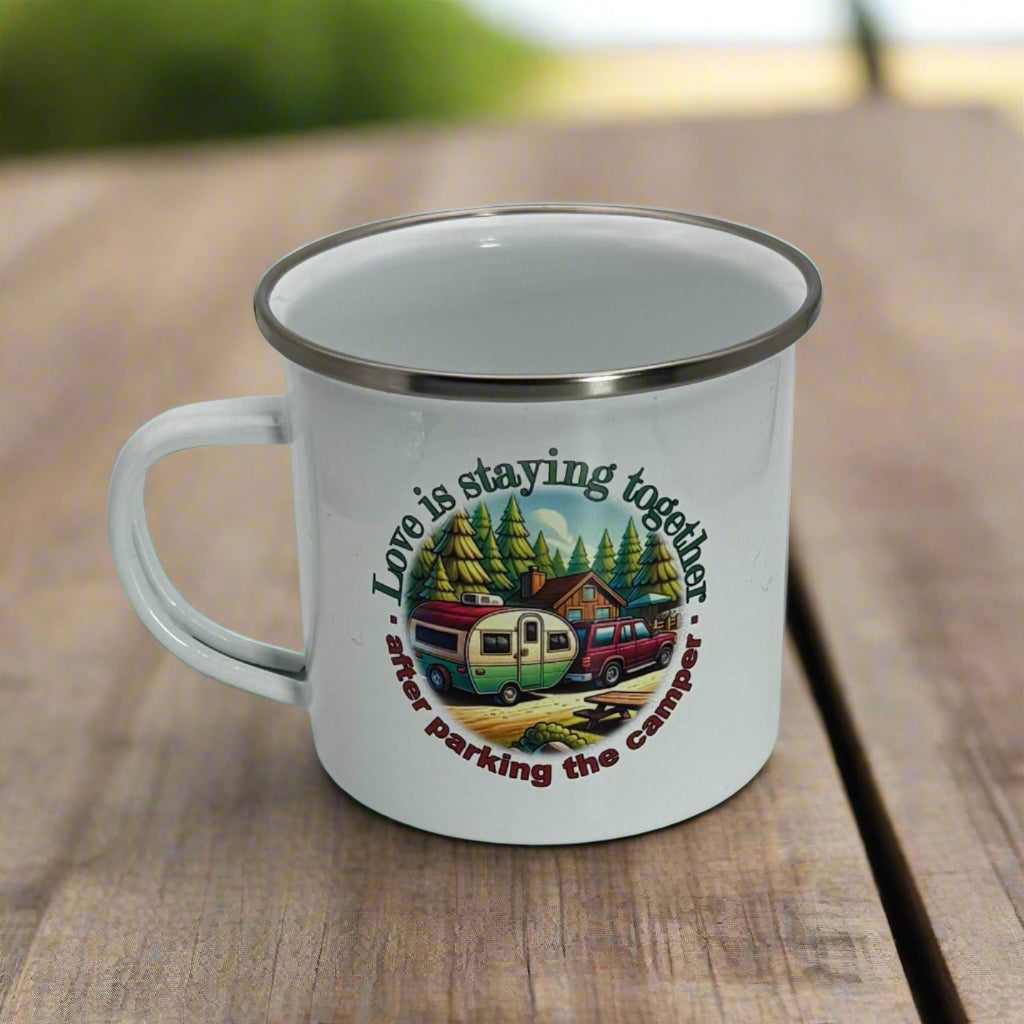 Enamel mug with camping design and text on a wooden picnic table.