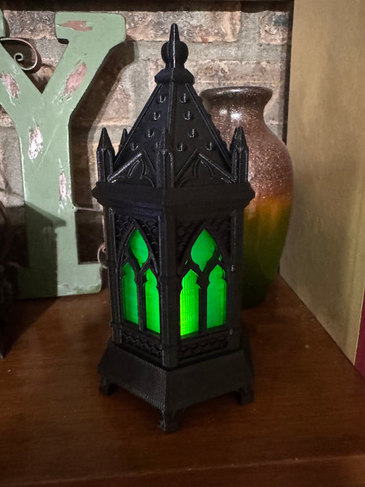 Black 3D printed gothic cathedral lantern with green glowing arched windows, Halloween mantel decor lit by an LED tea light