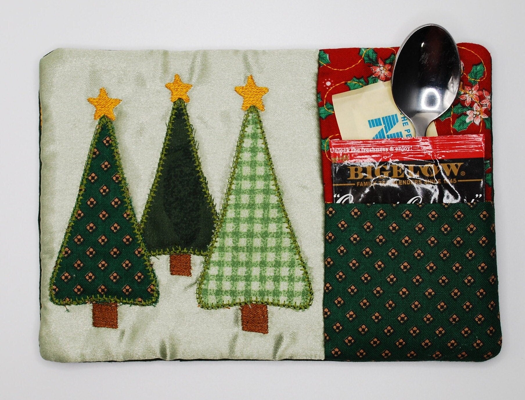 Fabric A mug run with  Christmas tree design and a spoon on a white background