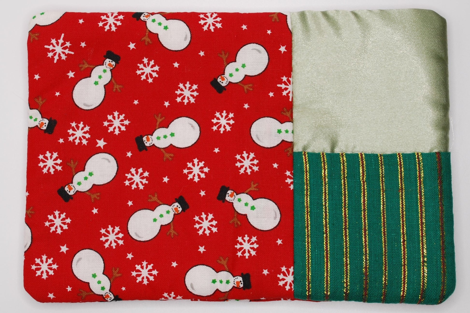 Red A mug run with snowman pattern and green striped fabric on a white background