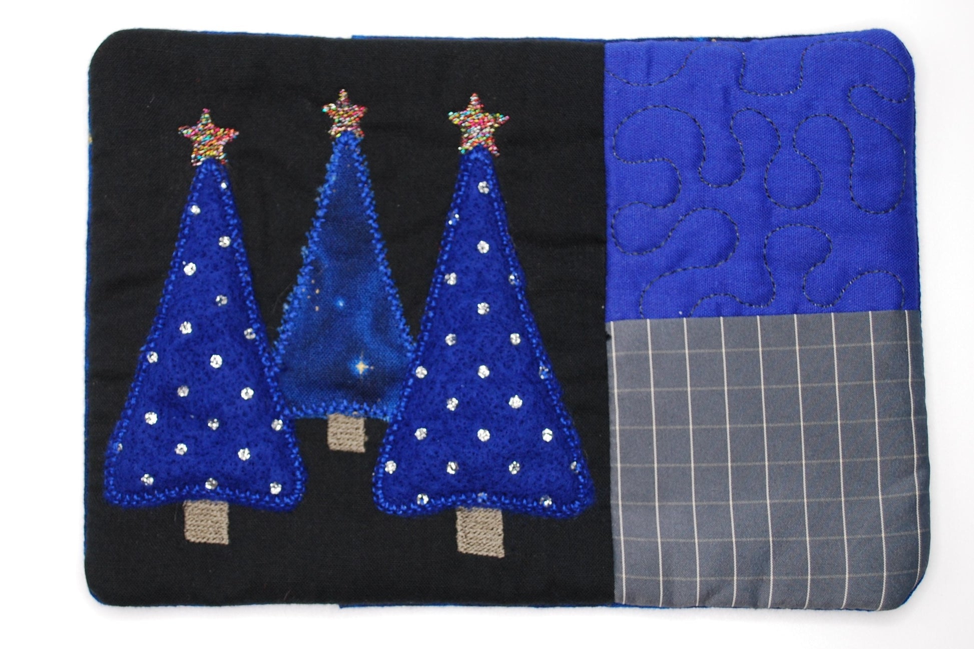 Patchwork fabric with blue trees and stars; mug run