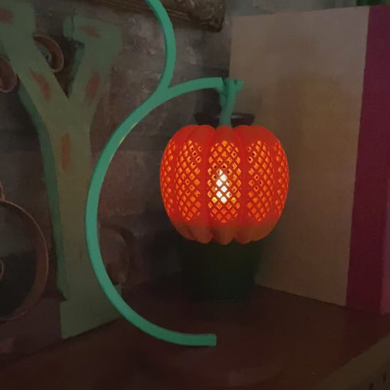 Video of the 3D printed pumpkin lantern glowing on its curved vine stand, lit by an LED tea light