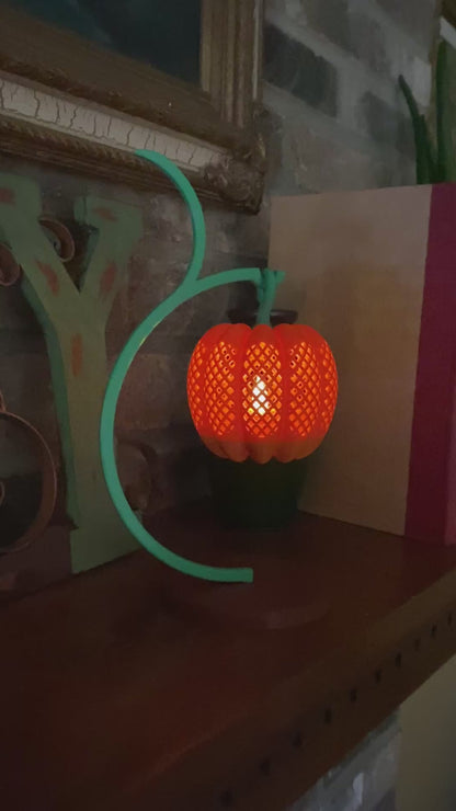 Video of the 3D printed pumpkin lantern glowing on its curved vine stand, lit by an LED tea light