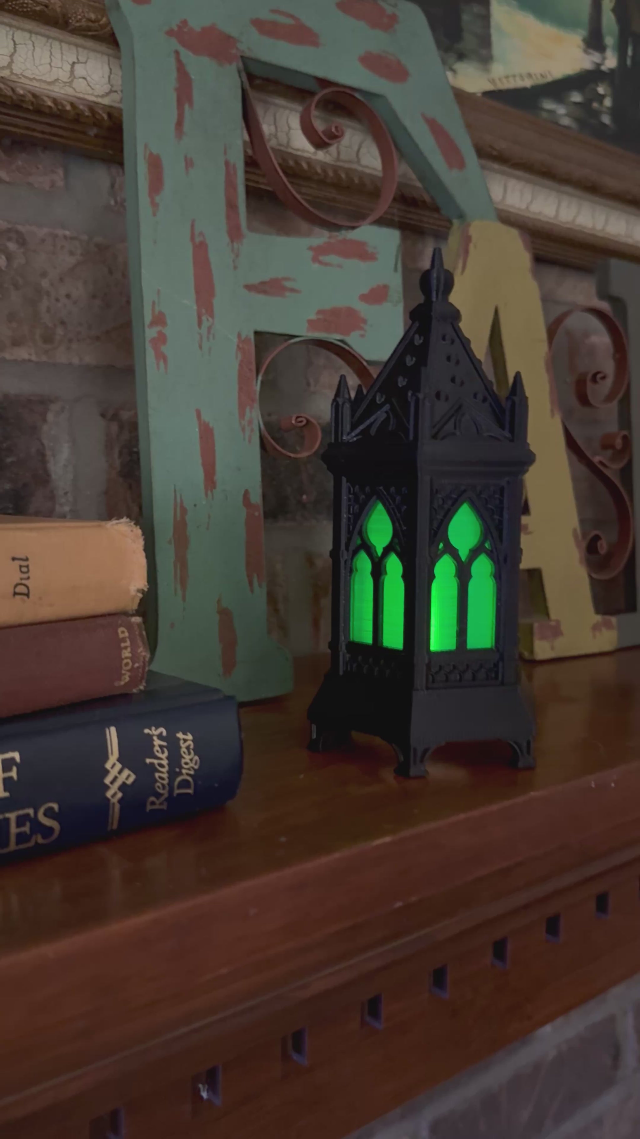 Video of a black gothic cathedral lantern with green glowing windows, moving in close on the pointed-arch tracery and back out.